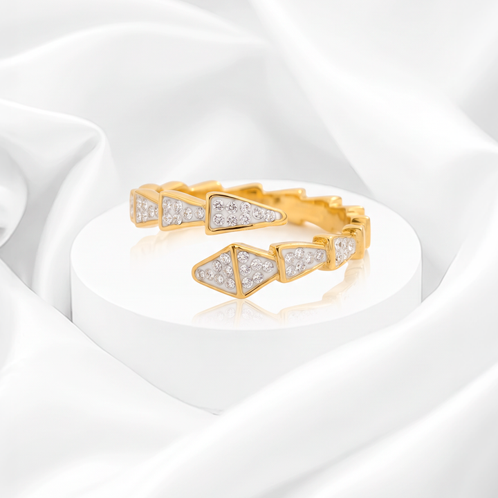 Anillo abierto para mujer marca Belle en acero bañado en oro de 18k estilo serpiente con triángulos de esmalte blanco y circonias.