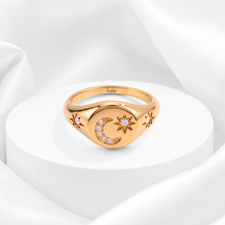 Anillo sello para mujer marca Belle en acero bañado en oro de 18k con grabado de luna y estrellas engastadas en circonias blancas.