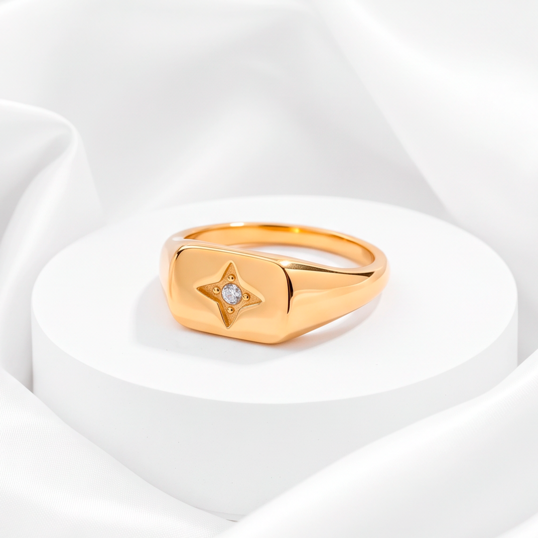 Anillo chunky estilo sello para mujer marca Belle en acero bañado en oro de 18k con grabado de estrella del norte y circonia blanca central.
