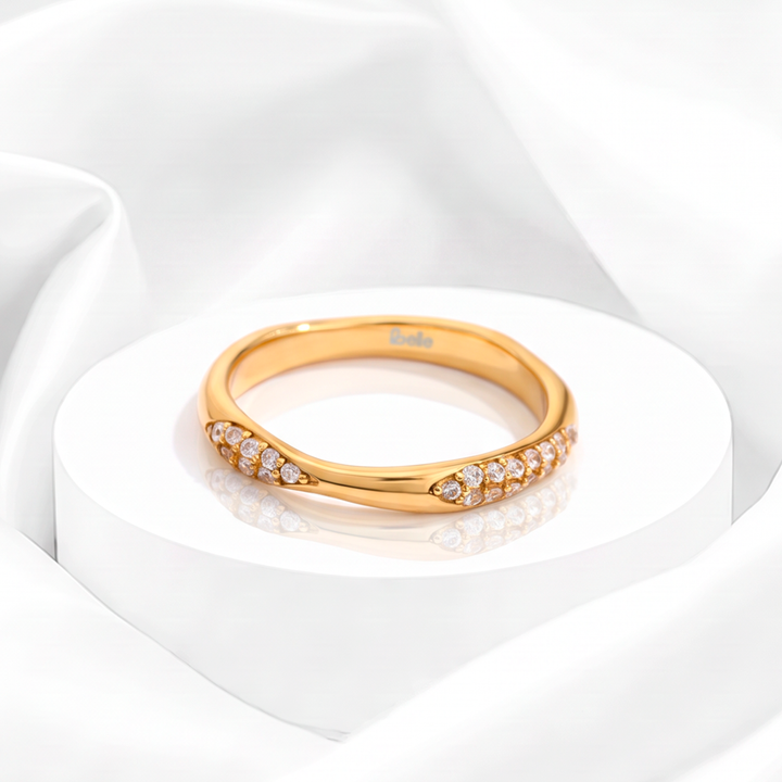 Anillo curvo para mujer marca Belle en acero bañado en oro de 18k con pavé de circonias blancas en los extremos.