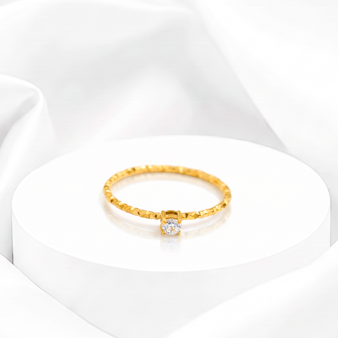 Anillo fino solitario para mujer marca Belle en acero bañado en oro de 18k con banda labrada y circonia blanca redonda.