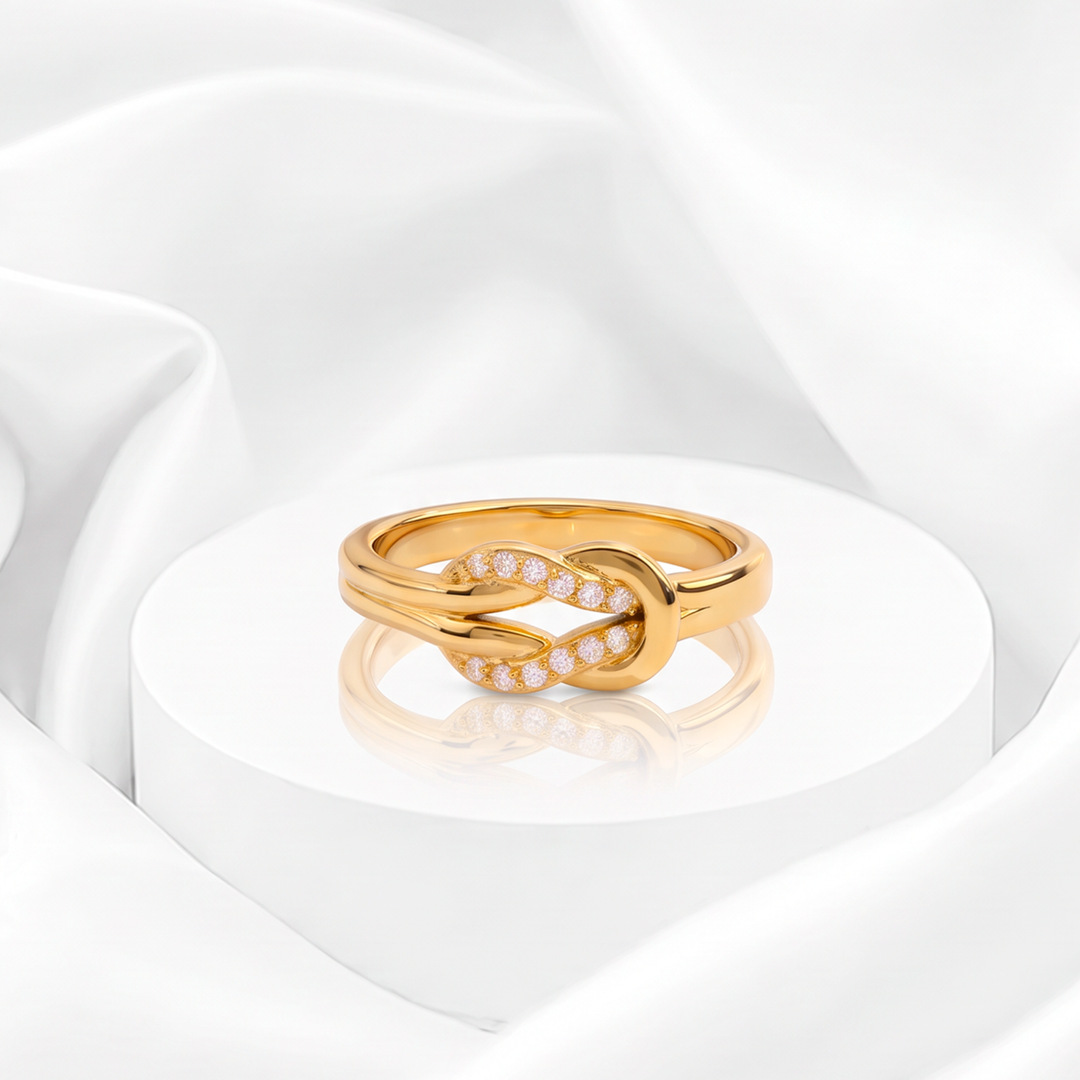 Anillo con diseño de nudo entrelazado y circonias pavé para mujer marca Belle en acero bañado en oro de 18k.