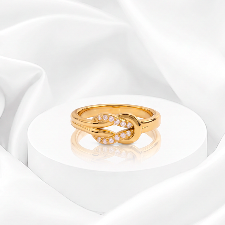 Anillo con diseño de nudo entrelazado y circonias pavé para mujer marca Belle en acero bañado en oro de 18k.
