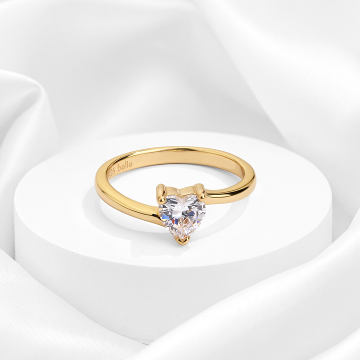 Anillo solitario con circonia brillante en corte corazón y brazos envolventes para mujer marca Belle en plata 925 bañada en oro de 18k.