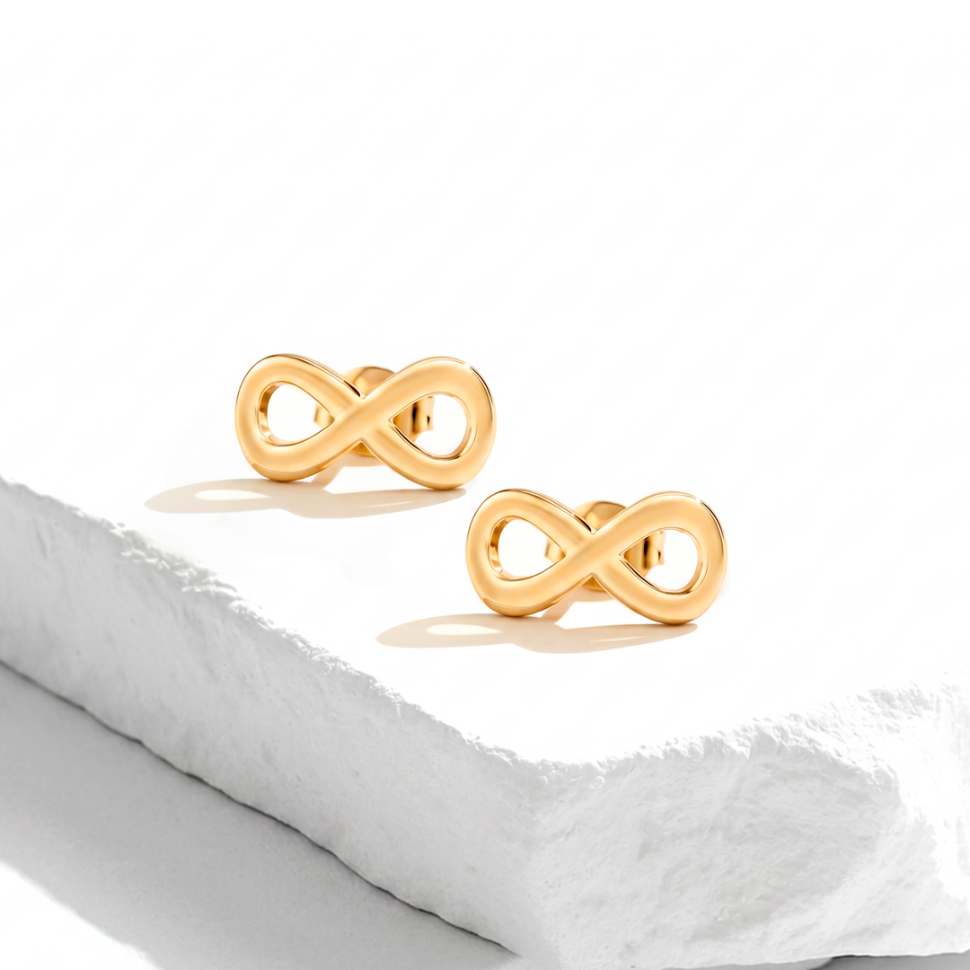 Aretes de broquel para mujer de acero quirúrgico 316 con baño de oro de 18k, con el diseño del símbolo del infinito en acabado pulido liso brillante.