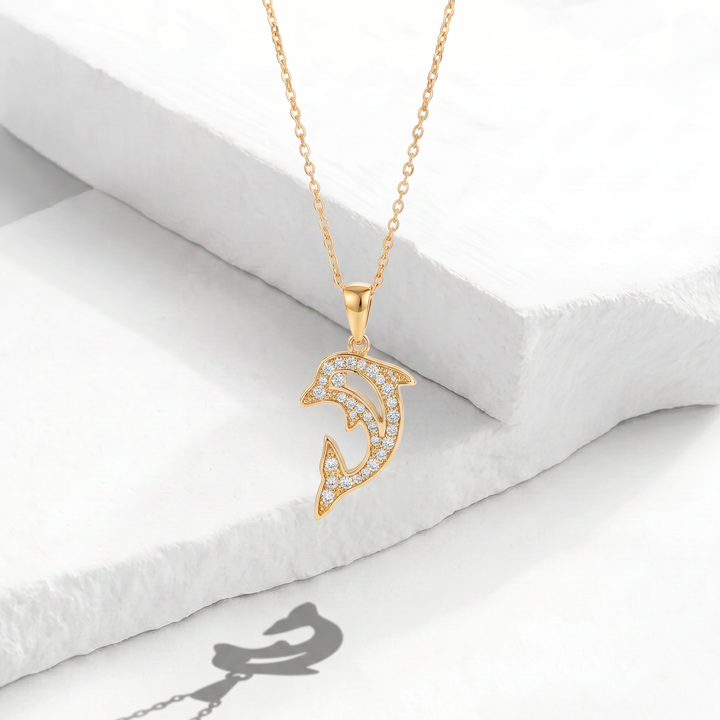 Collar para mujer marca Bodo con cadena fina de acero inoxidable bañado en oro de 18k y dije colgante de delfín saltando con cristales blancos circulares.