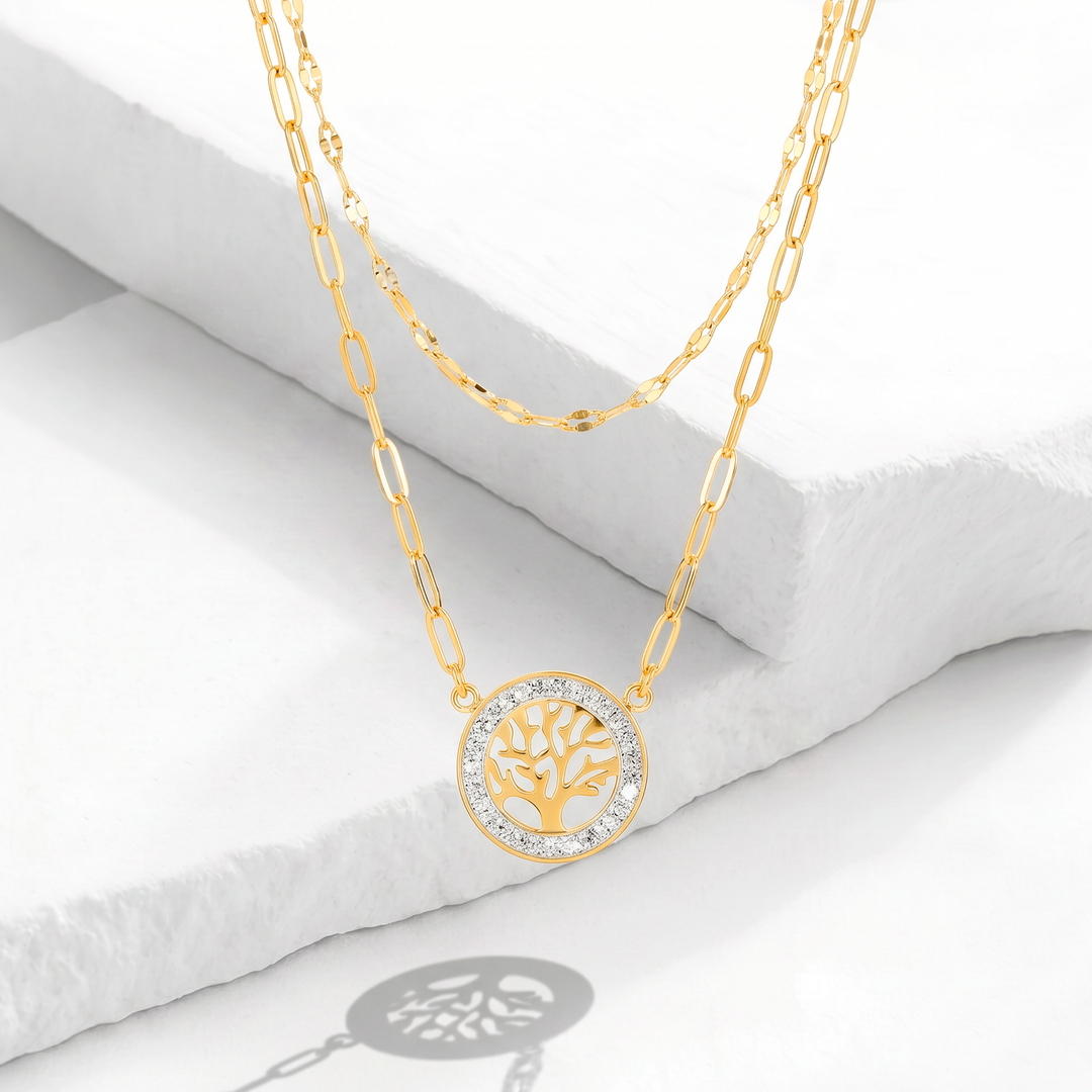 Collar de doble cadena para mujer marca Bodo en acero inoxidable bañado en oro de 18k con dije circular calado del Árbol de la Vida y contorno de cristales blancos.