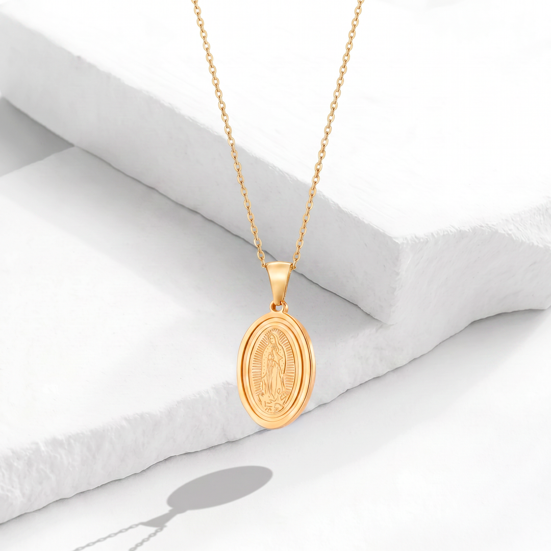 Collar dorado para mujer de acero quirúrgico 316 con baño de oro de 18k, que muestra una cadena fina y un dije de medalla ovalada de la Virgen de Guadalupe en relieve.