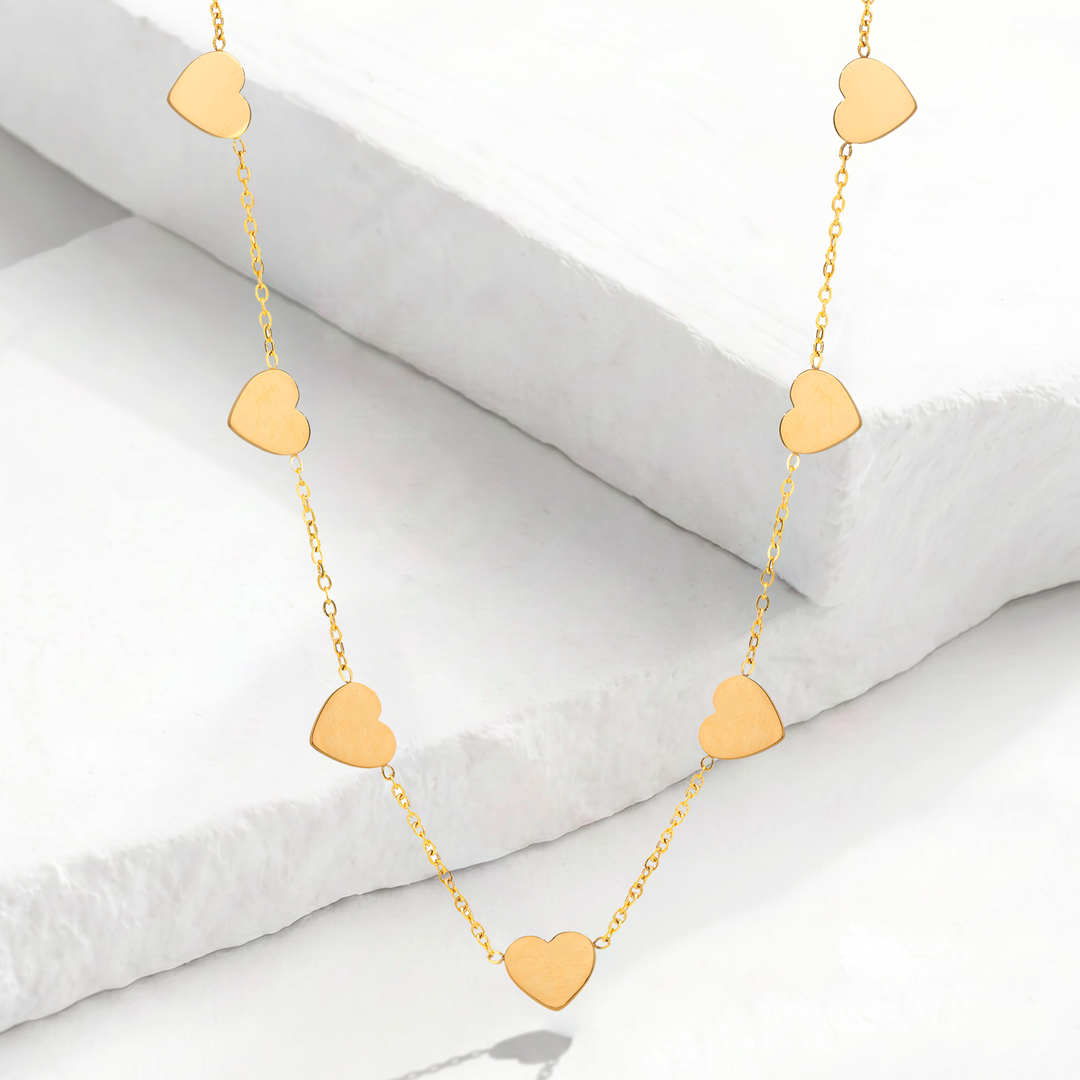 Collar gargantilla para mujer con cadena fina de acero inoxidable bañado en oro de 18k y nueve mini dijes de corazón lisos y colgantes con pulido espejo.