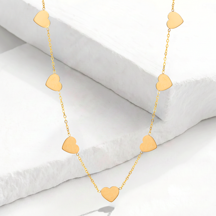 Collar gargantilla para mujer con cadena fina de acero inoxidable bañado en oro de 18k y nueve mini dijes de corazón lisos y colgantes con pulido espejo.