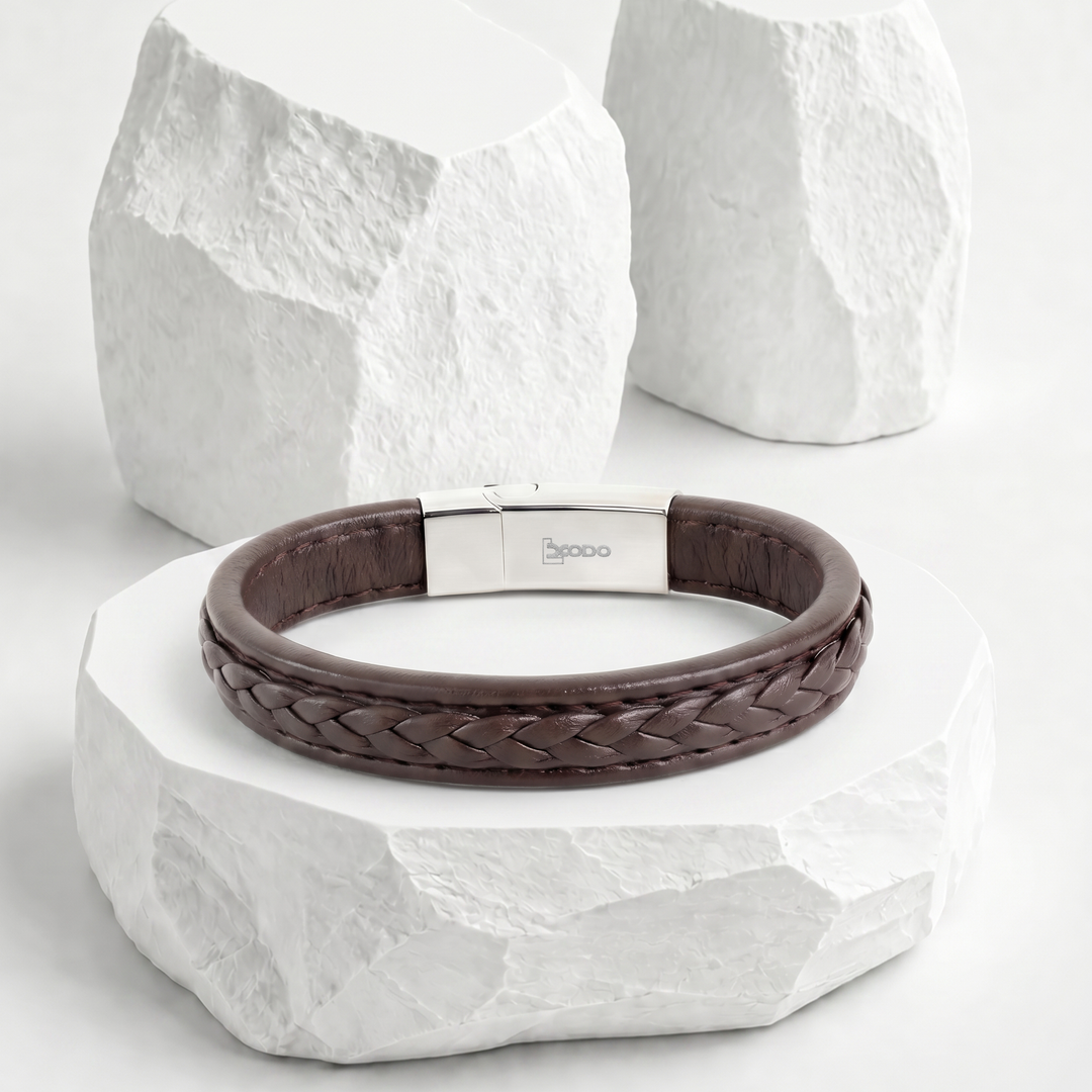 Pulsera para hombre de biocuero marrón oscuro con diseño trenzado central y broche rectangular magnético de acero inoxidable plateado.