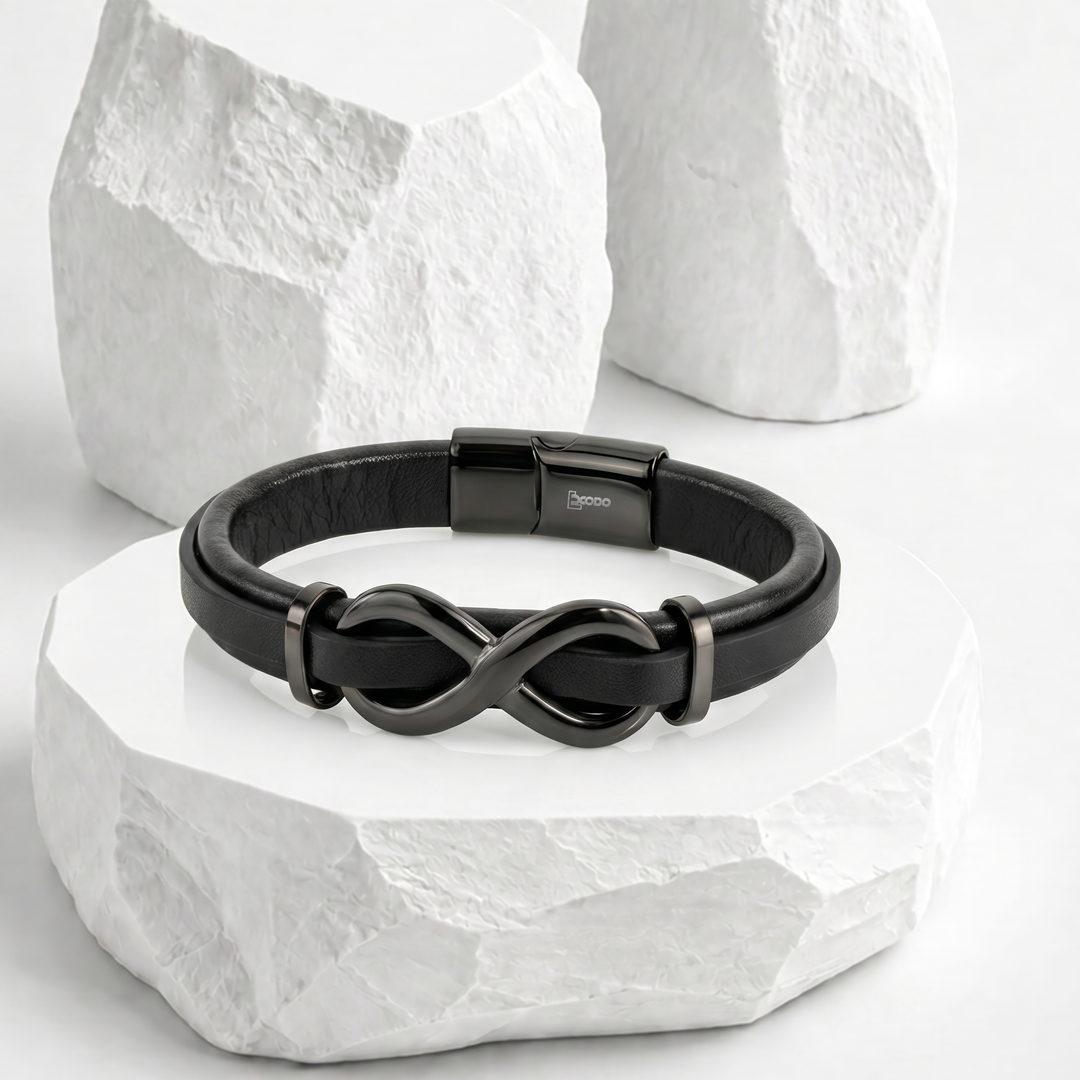 Pulsera para hombre de biocuero negro con un dije central del símbolo del infinito y broche rectangular magnético en acero inoxidable pulido negro.