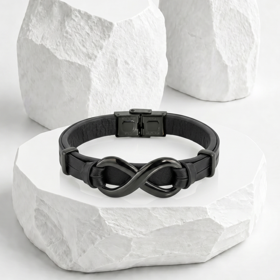 Pulsera para hombre de biocuero negro con diseño de doble banda paralela, equipada con un dije de infinito entrelazado y broche desplegable de acero inoxidable negro.