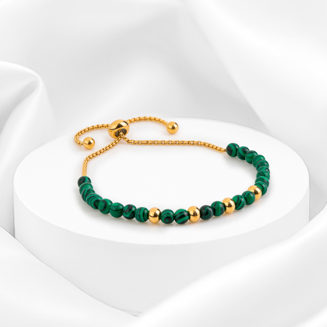 Pulsera dorada de mujer en acero 316L oro 18k ajustable con cuentas de aventurina verde y esferas doradas sobre fondo blanco.