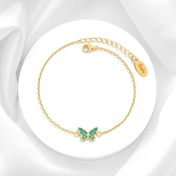 Pulsera para mujer marca Belle con cadena fina de eslabones de acero bañado en oro de 18k y dije de mariposa esmaltada en color turquesa verdoso.