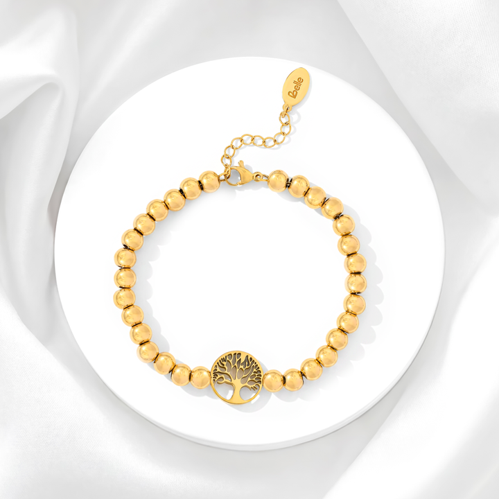 Pulsera de mujer de acero quirúrgico 316 con baño de oro de 18k, compuesta por una hilera de esferas doradas lisas pulidas y un dije circular calado del Árbol de la Vida.