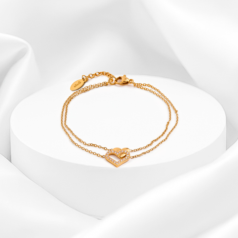 Pulsera doble cadena de mujer en acero quirúrgico 316 baño oro 18k con dije central de doble corazón entrelazado con cristales blancos pavé sobre soporte redondo.