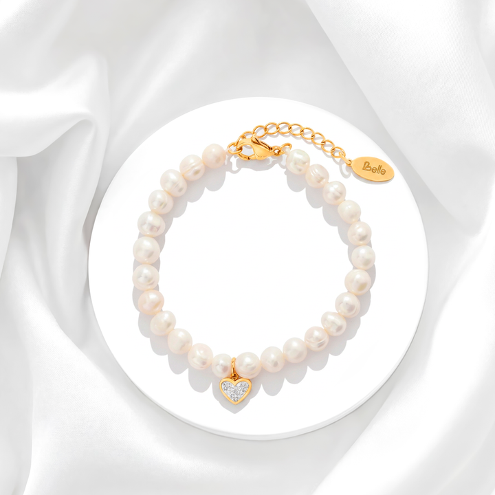 Pulsera de perlas de río naturales para mujer con broche de acero quirúrgico en baño de oro de 18k y un dije de corazón colgante con cristales blancos.