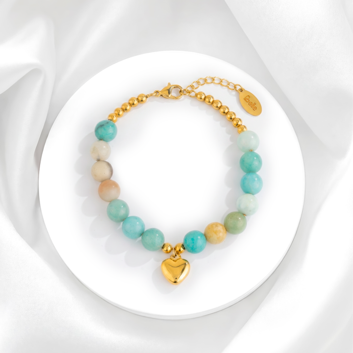 Pulsera para mujer marca Belle de acero quirúrgico 316 con baño de oro de 18k, hecha con esferas de piedra natural amazonita verde y un dije de corazón abombado liso.