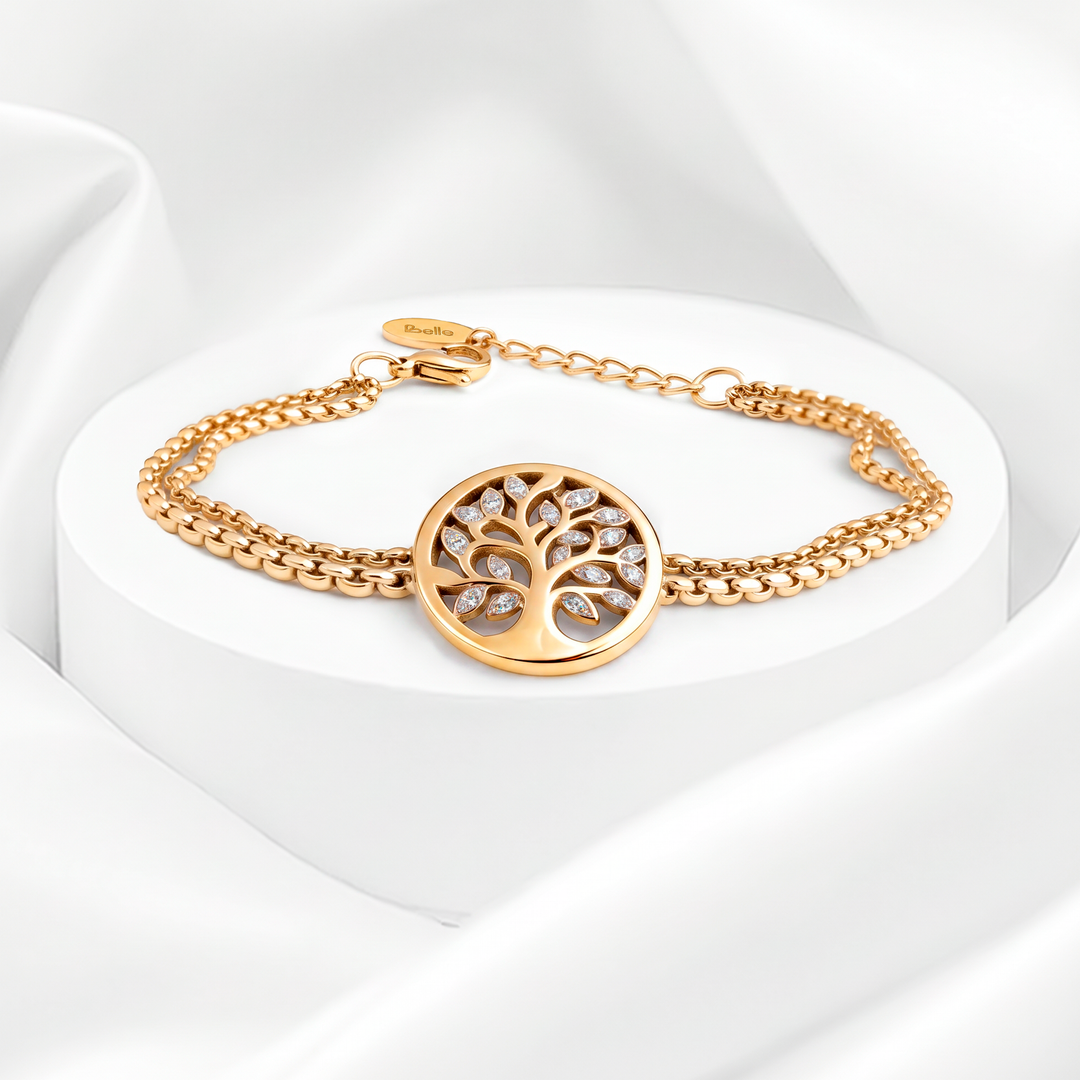 Pulsera semirrígida de mujer en acero quirúrgico 316 con baño de oro de 18k, de doble cadena trenzada y dije circular calado del Árbol de la Vida con cristales blancos.