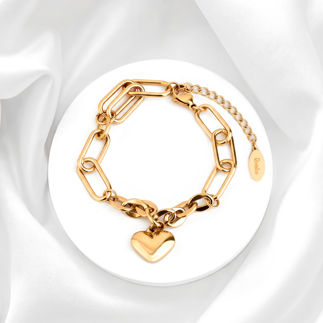 Pulsera de mujer con eslabones largos estilo paperclip en acero quirúrgico 316 con baño de oro de 18k y un dije colgante de corazón abombado tridimensional pulido brillante.