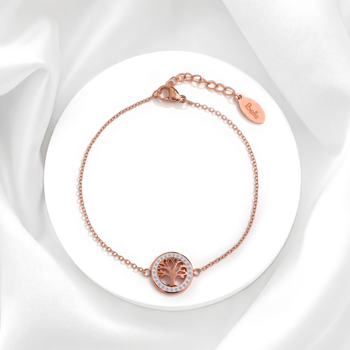 Pulsera de tres hilos para mujer en acero quirúrgico 316 baño oro rosa 18k con dije circular del árbol de la vida y cristales blancos sobre base redonda.